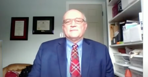 一个坐在书架旁边的男人