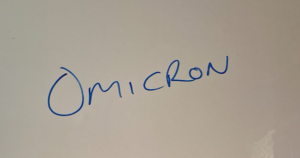 用蓝色墨水写在一张纸上的欧米克隆这个词。