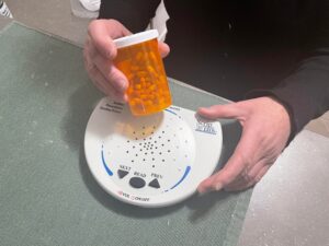 Milena演示了如何使用ScripTalk机器，她通过手持机器扫描一瓶药物，然后机器读取如何服用药物的说明。