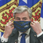 蒂姆·休斯顿在新冠疫情简报会上摘下了他的格子呢口罩