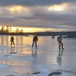 日落时在湖面上滑冰的人