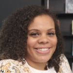 拉简·威利斯，一位留着齐肩卷发、面带可爱微笑的黑人女性