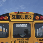 明亮的蓝天映衬着一辆黄色校车的尾部