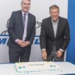 史蒂芬·麦克尼尔和米其林总裁斯科特·克拉克在切蛋糕时微笑着