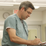 一个白人医生在医院填写文件