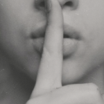 一个手指的特写镜头在嘴的嘴在嘘的姿态