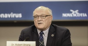 一个男人坐在视频屏幕前的桌子前