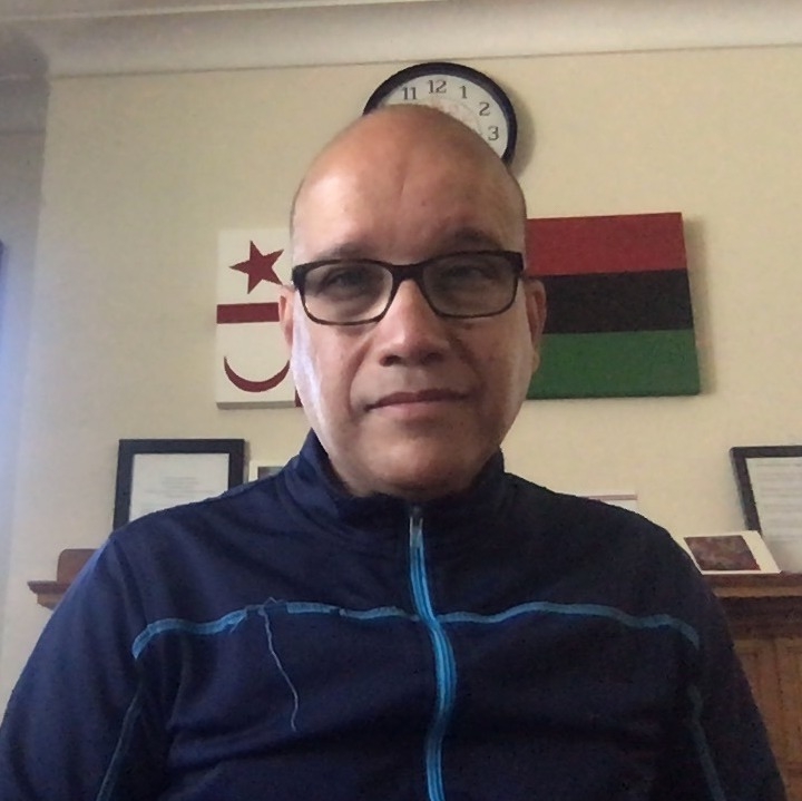 戴着黑色眼镜，身穿海军蓝运动衫的黑人男子