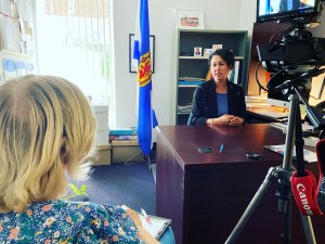 一个金发女人和另一个坐在桌旁的女人谈话。