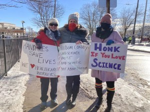 三名妇女在哈利法克斯举着抗议标语