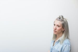 一张女人的照片，一头金色长发，身穿一件淡黄色衬衫。