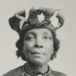 a black and white photo of Lucy Miitchell, a Black woman wearing an interesting hat