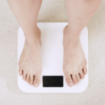 A white person's feet on a bathroom scale.