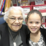 微笑与一个年轻黑人女孩的一个资深黑人夫人在教室里