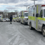 护理人员走过一大阵容的救护车