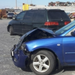 the crumpled front end of a bright blue hatchback