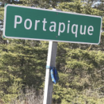 the Portapique road sign wiith a tartan sash on the post