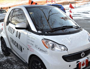 A small vehicle that says 'Keep on truckin' with false statistics about the federal vaccination program, including that 10% were forced at gunpoint.