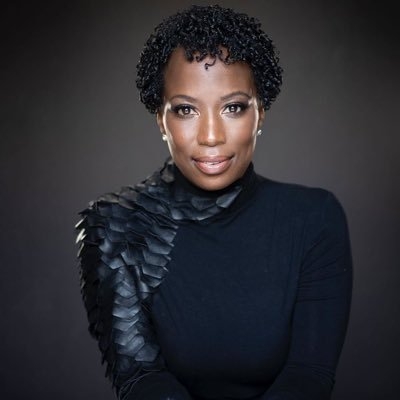 黑色的女士与短卷发，黑色的包裹和黑色的背景。