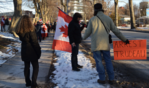 Rally supporters with Canadian flags and an 'Arrest Trudeau' sign