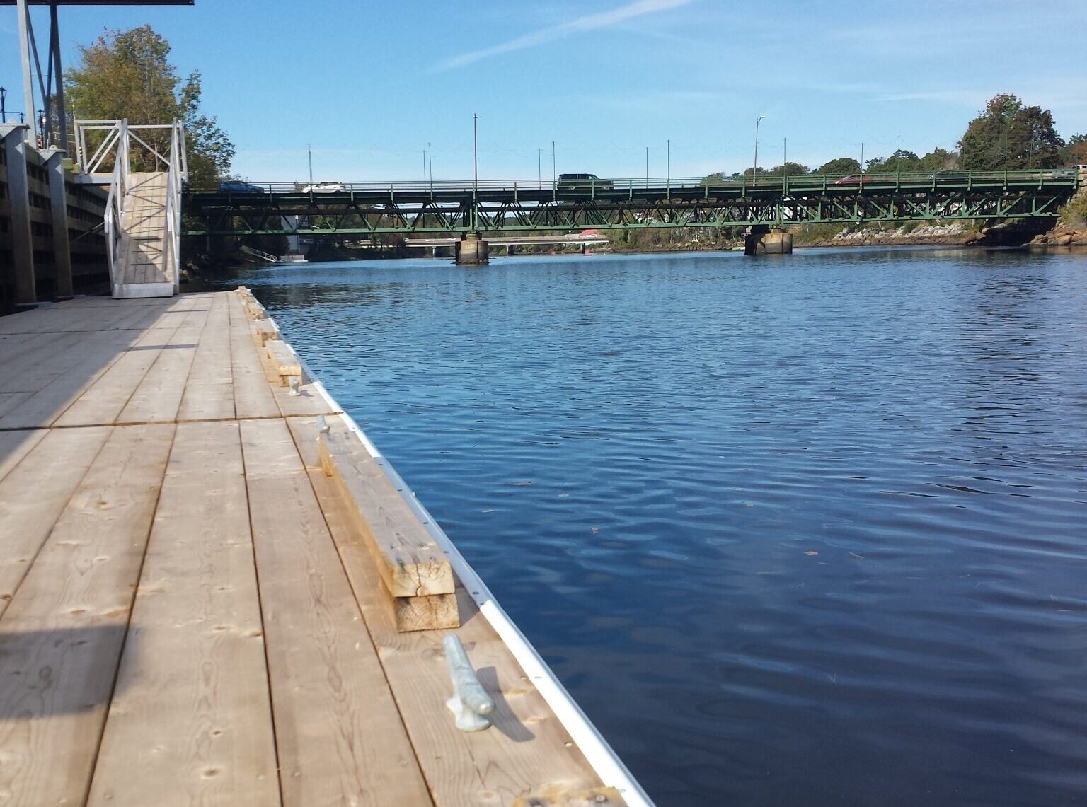 停泊在平静的碧水旁。背景中有一座桥。