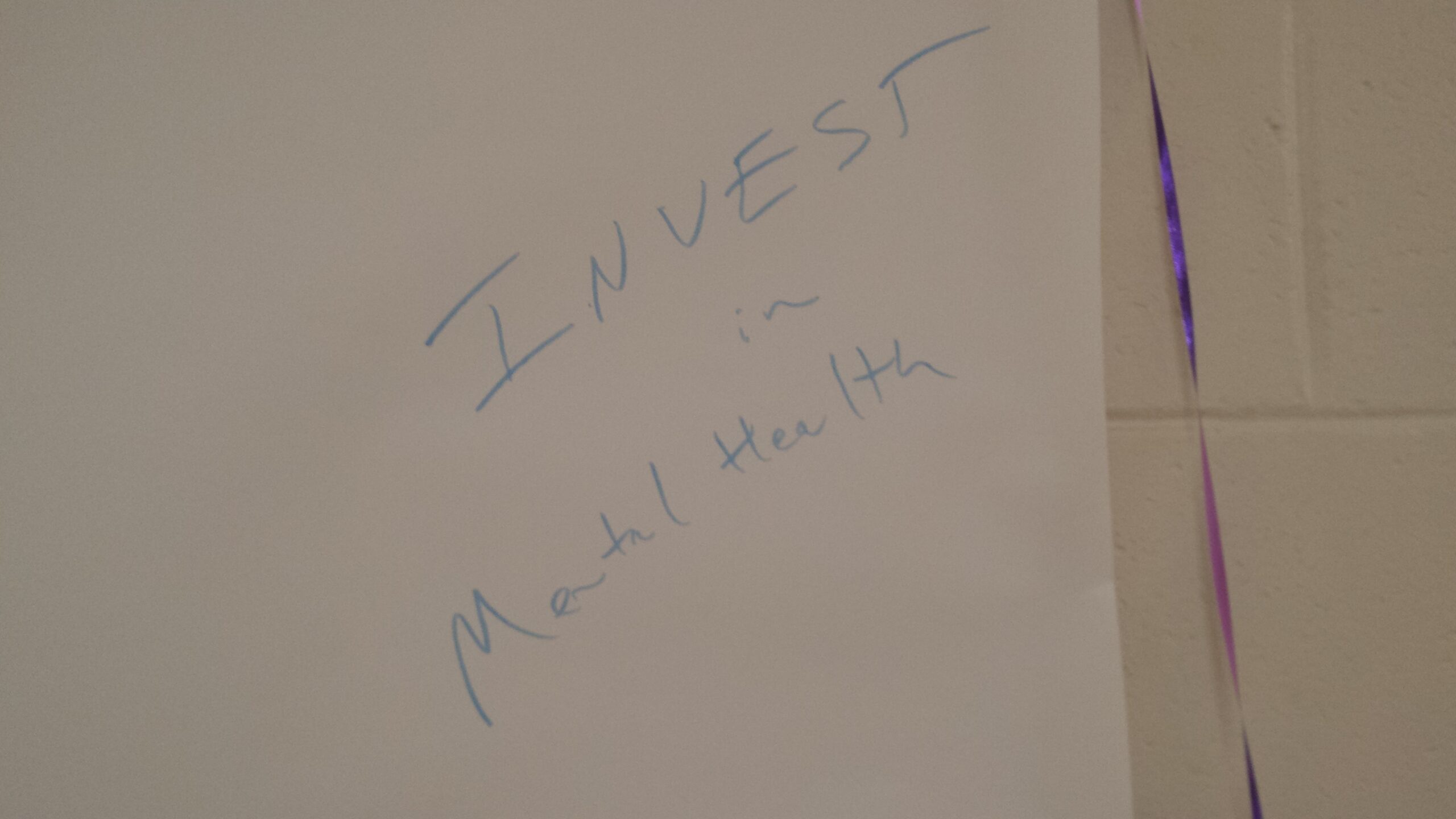 “投资精神健康”用记号笔写在一张白板纸上