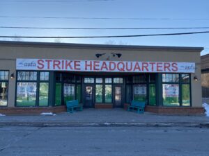 在3月一个寒冷的日子里，一座有玻璃门的单层建筑。大楼上挂着“罢工总部”的横幅