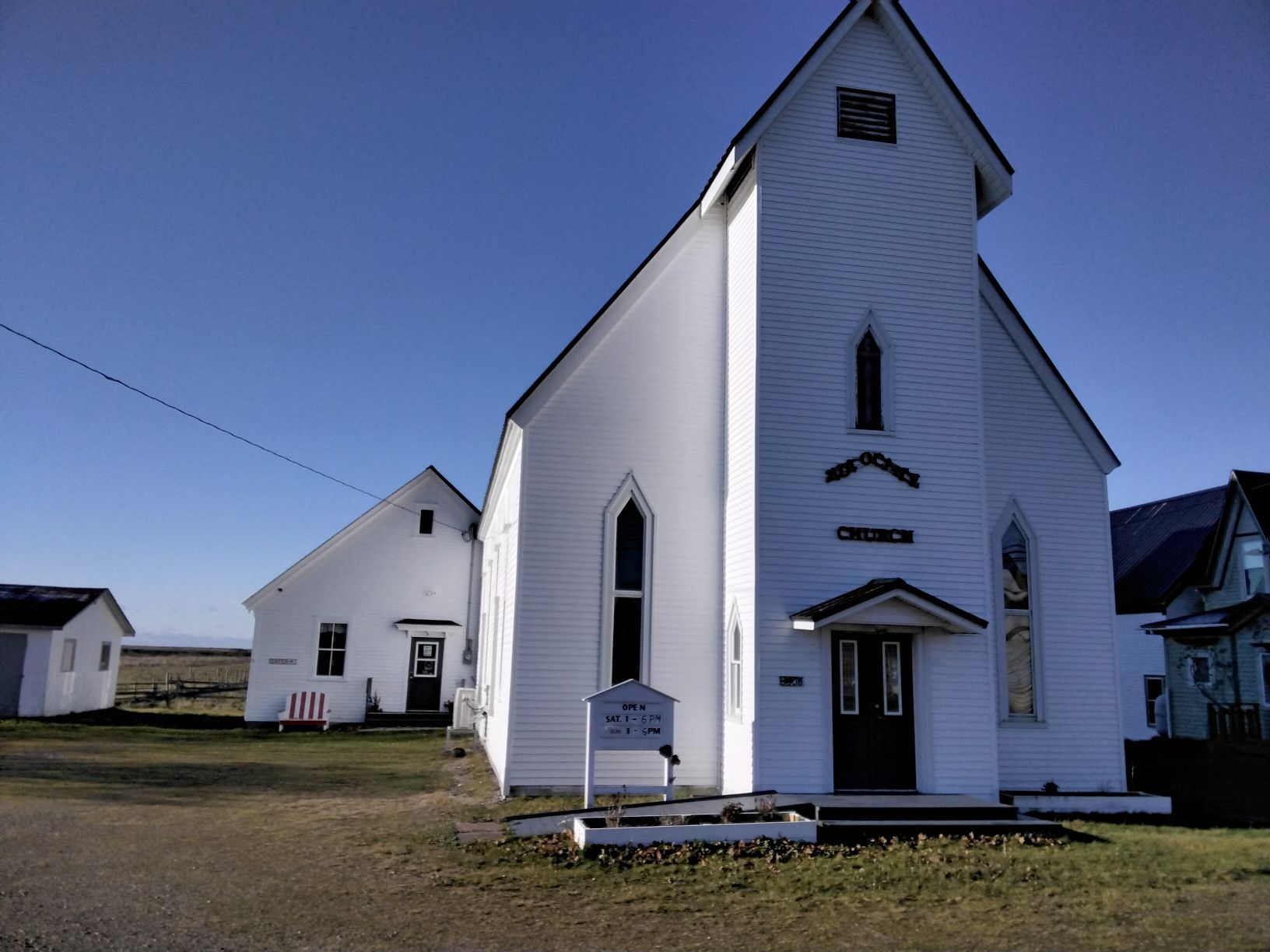 一座古老的白色教堂，后面有一个白色的教堂大厅。