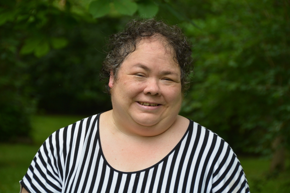 一张照片，一个留着短卷发的女人穿着黑白条纹上衣