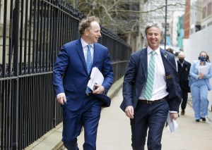 两个穿着西装的男人走在哈利法克斯市中心的一条街上。