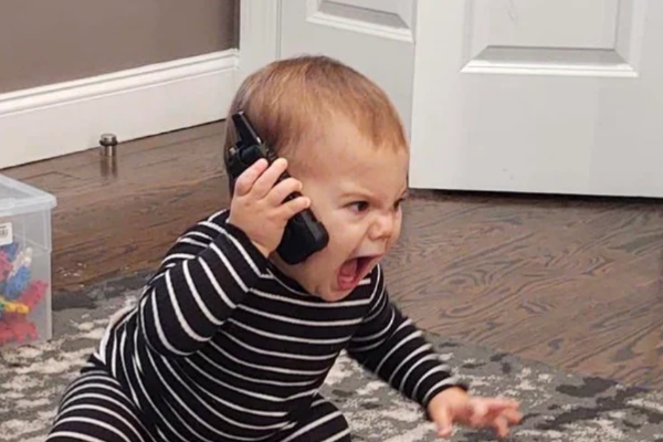 一个愤怒的小孩对着手机大喊大叫。