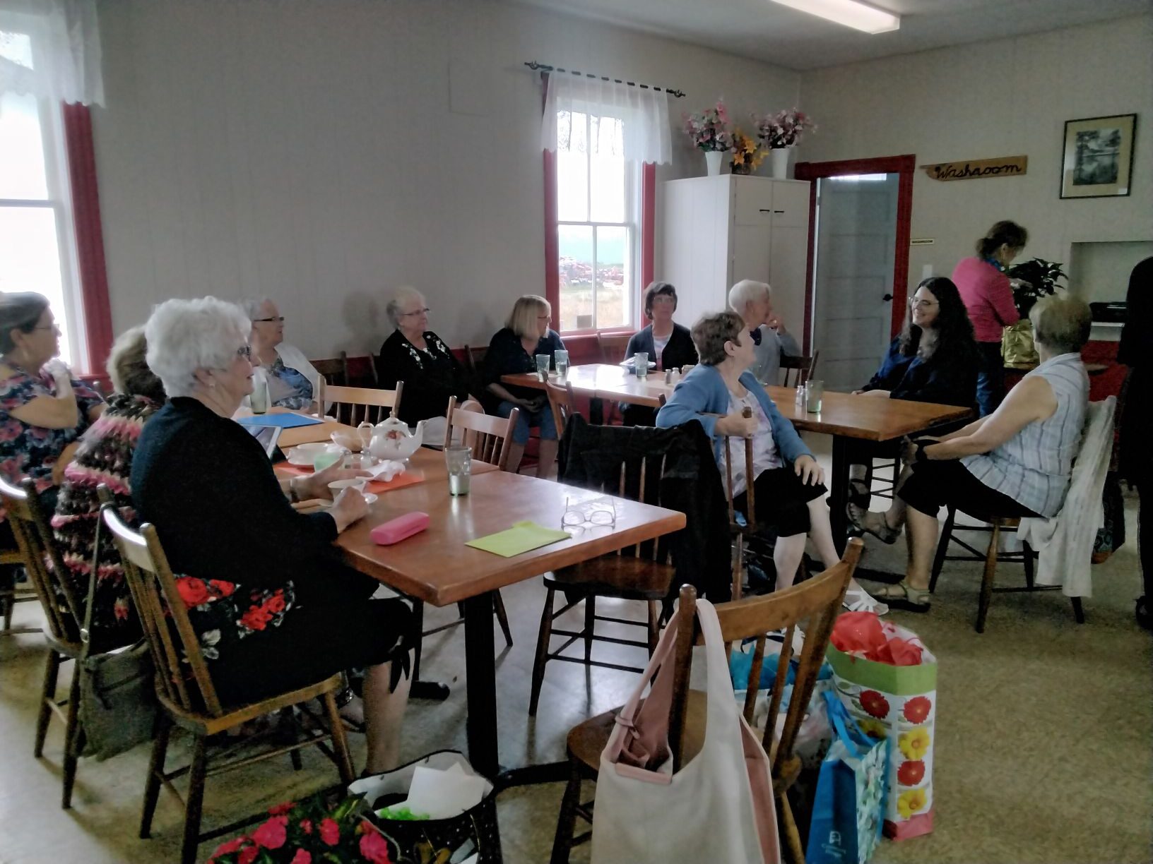 顾客们坐在咖啡馆的桌子旁。