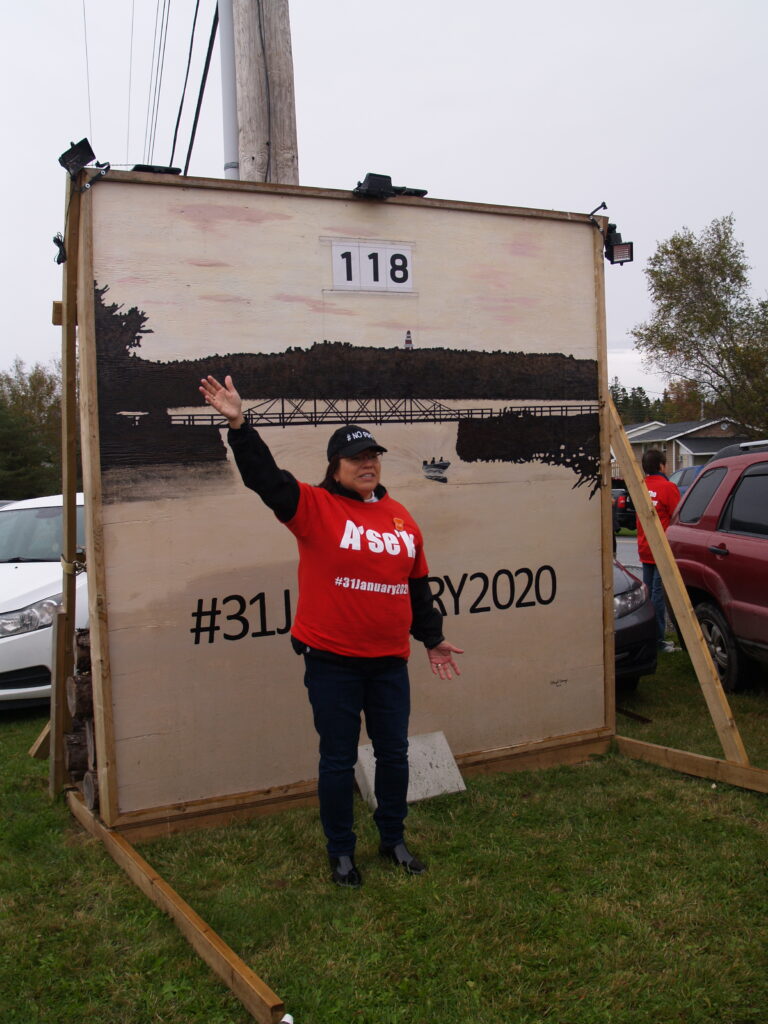 2019年，Pictou Landing First Nation在乐队办公室前的一块大招牌上倒数着船港关闭的日子，在这张照片中，首席执行官安德里亚·保罗(Andrea Paul)指着只剩下118天的招牌。