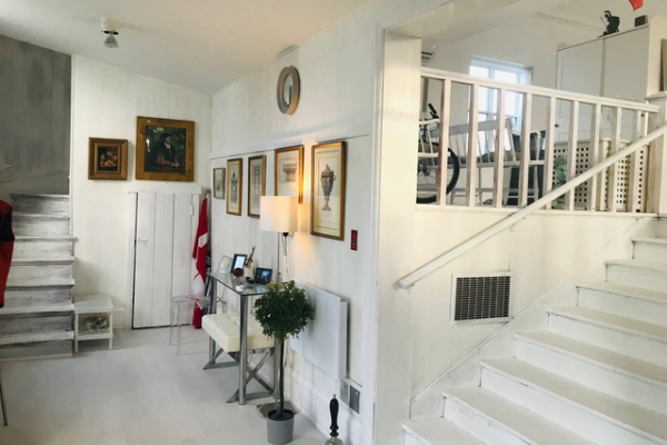 一个翻新的走廊，有楼梯，墙上装饰着照片，灯，旗帜和植物。