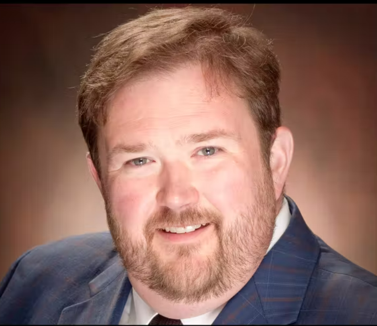 一个留着沙黄色头发和山羊胡子的中年白人男子的头像。