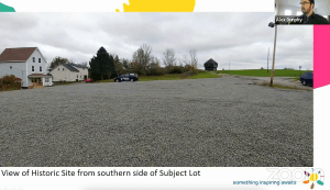 一个砾石停车场，左边有两栋房子，中间和右边有一座堡垒。