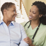 两个黑人妇女微笑着，其中一个穿着手术服，戴着听诊器