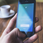 一只手拿着手机，打开着Twitter应用