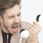 一个年轻的白人对着旋转电话大喊大叫