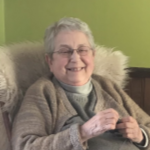 A senior white lady laughs while sitting in a very comfy chair