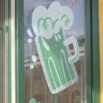 A green beer mug painted on the window of a pub