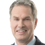 A smiling white middle aged man in a suit