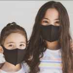 An Asian woman and an Asian girl, both smiling in black masks