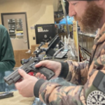 一个身穿迷彩服的白人男子在检查手枪