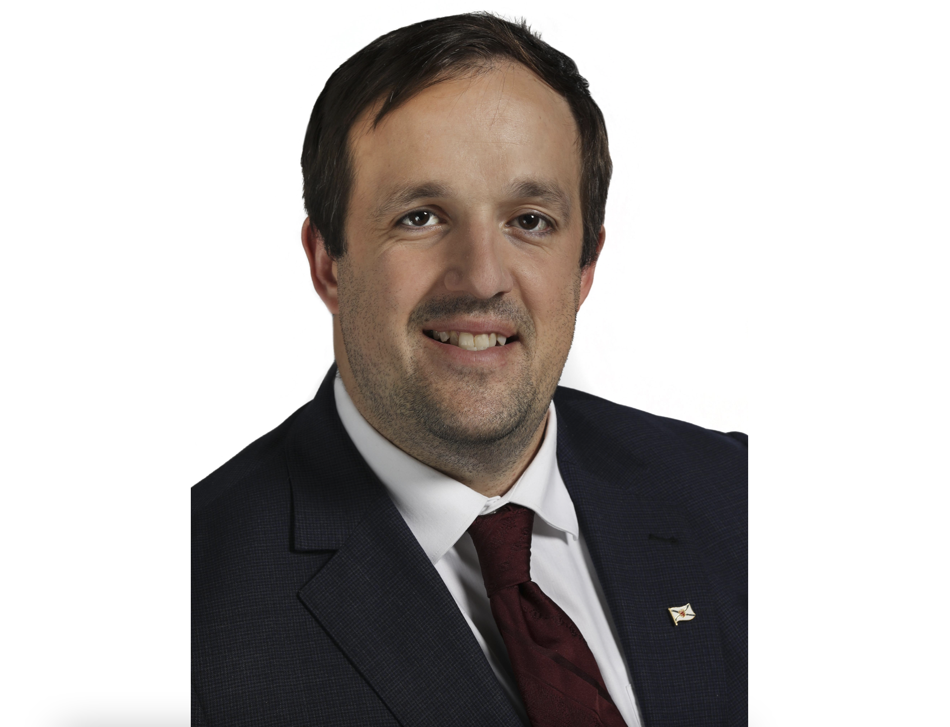 一个微笑的男人在白色背景下穿着深色西装外套，白色衬衫，戴着酒红色领带。