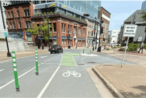 有自行车道、老建筑和十字路口的街道照片。