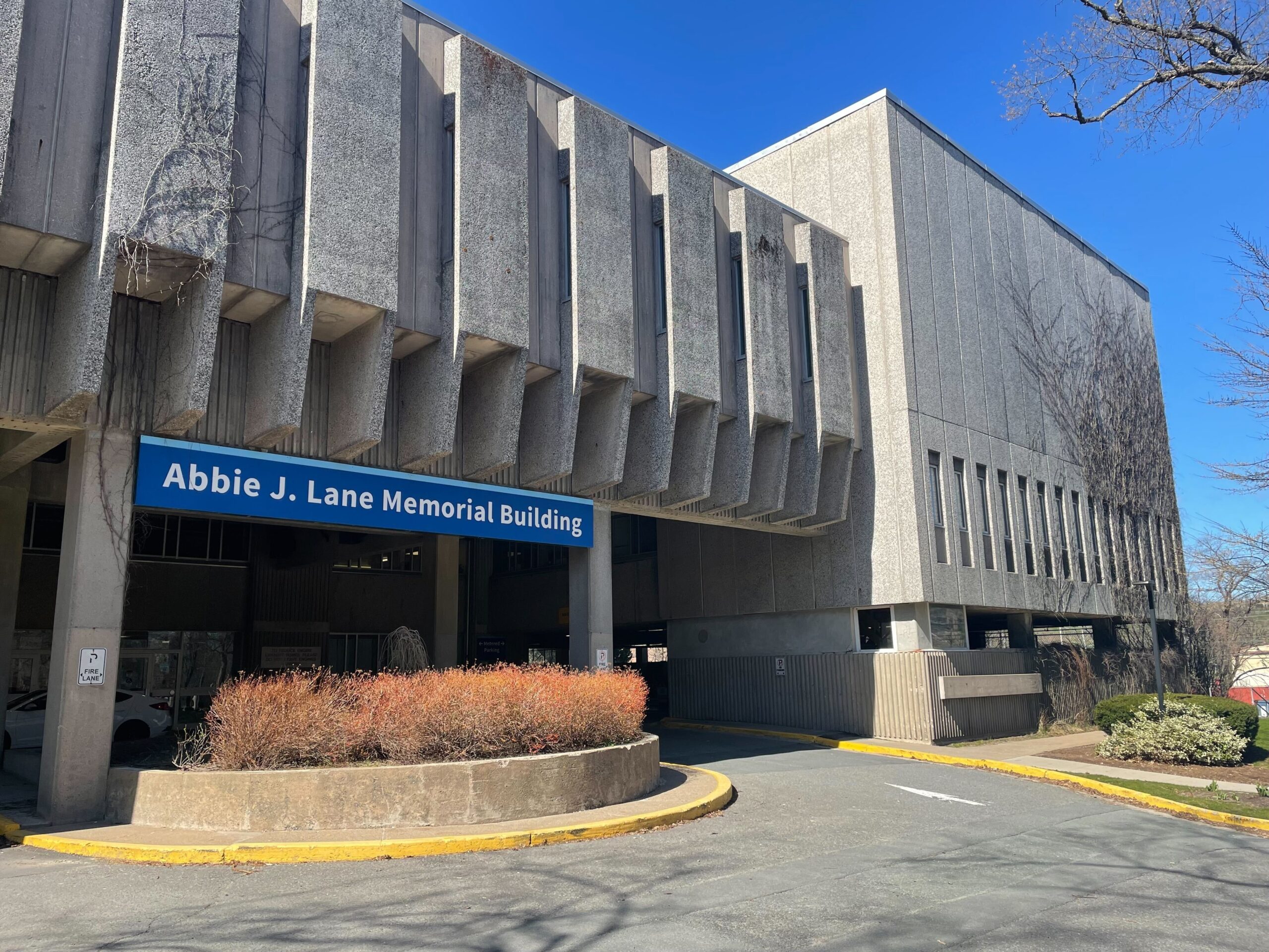 一座水泥建筑，入口处有个蓝色标志，上面写着艾比·j·莱恩大楼
