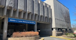 一座水泥建筑，上面有一个蓝色的牌子，写着艾比·j·莱恩大楼