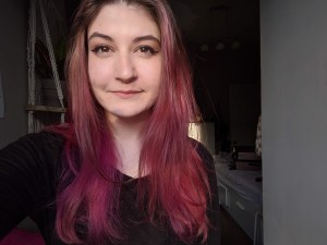 一个染成紫红色长发的年轻女子的头像。