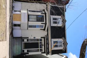 一栋白色的传统房子，现在已经空了。正面是拆除的标志。